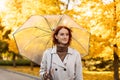 Serious pretty young european red-haired lady in raincoat with umbrella walks alone in rain in autumn Royalty Free Stock Photo