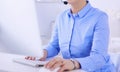 Serious pretty young woman working as support phone operator with headset in office Royalty Free Stock Photo