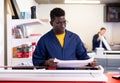 Serious print shop worker cuts paper on professional cutter Royalty Free Stock Photo