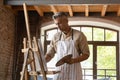 Serious professional artist man in craft apron working in studio