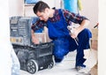 Worker looking for necessary tool in toolbox