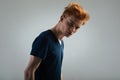 Serious red-haired young man wearing a black shirt