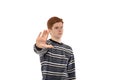 Serious redhead young boy teenager with a hand gesture shows Stop drugs or wars or pollution, isolsted