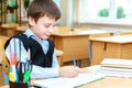 Serious schoolboy in the classroom. Primary school student.