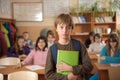 Serious schoolboy in front of class