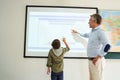 Serious schoolboy solving chemical problems using interactive whiteboard Royalty Free Stock Photo