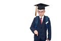 Serious schoolboy in a suit, glasses and an academic hat is pointing down. School concept. Isolate