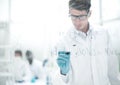 Serious scientist writes a chemical formula on a glass Board.