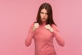 Serious self confident woman with brown hair holding clenched fists up ready to make blow, attack, self defence courses Royalty Free Stock Photo