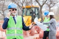 Serious senior architect or businessman talking on the phone while working on a construction site Royalty Free Stock Photo