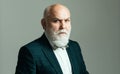 Serious Senior. Confident senior bearded man in a suit and tie stand on gray isolated background. Fashion adult.