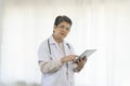 Confident senior female doctor using tablet computer standing in clinic. Royalty Free Stock Photo