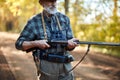 Serious senior hunter holding shotgun