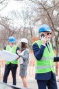 Serious senior male and young female architects or business partners looking at building blueprints