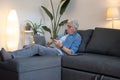 Serious senior man lying on sofa and buying products online Royalty Free Stock Photo