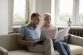 Serious senior retired family couple using laptop for domestic payment
