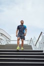 Serious about staying in shape. Low angle shot of a young man out for a run in the city. Royalty Free Stock Photo