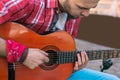 Serious street musician making guitar practice easier