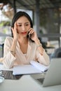 Serious and stressed millennial Asian businesswoman is on the phone with someone Royalty Free Stock Photo