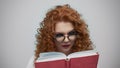 Serious student holding book in studio. Portrait of girl turning pages of book Royalty Free Stock Photo