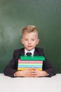 Serious student hugging a stack of books Royalty Free Stock Photo