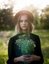 Serious sunny portrait of a stylish girl in a straw hat with a Royalty Free Stock Photo