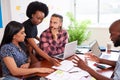 Serious team of developers brainstorming new app idea in boardroom meeting