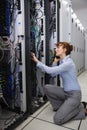 Serious technician talking on phone while analysing server