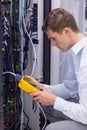 Serious technician using digital cable analyzer on server Royalty Free Stock Photo