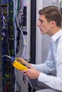 Serious technician using digital cable analyzer on server Royalty Free Stock Photo