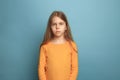 The serious teen girl on a blue background. Facial expressions and people emotions concept