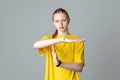 Serious teen girl making time out gesture , isolated on light grey background, wearing in casual blank yellow t shirt. Stop, no,