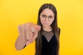 Serious teen girl wearing glasses because of bad eyesight and pointing finger on camera, selective focus, mood Royalty Free Stock Photo