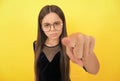 serious teen girl wearing glasses because of bad eyesight and pointing finger on camera, selective focus, mood Royalty Free Stock Photo