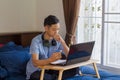 Serious teenage of Asian man thinking in front of laptop
