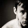 Serious Teenage Boy with Hand Resting on Neck Royalty Free Stock Photo