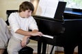 Serious teenage boy looking down at piano keys Royalty Free Stock Photo