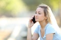 Serious teenage girl talking on phone in a park Royalty Free Stock Photo
