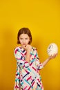 Serious teenager girl holding Ostrich egg with funny face Royalty Free Stock Photo