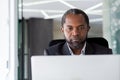 Serious thinking boss businessman close up, african american man working with laptop, man reading from computer screen Royalty Free Stock Photo