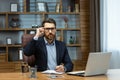 Serious thinking boss inside the office, portrait of a mature businessman with a beard and glasses, the man is looking Royalty Free Stock Photo