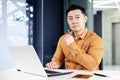 Serious thinking businessman inside office at workplace working with laptop, mature experienced and confident asian Royalty Free Stock Photo