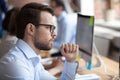 Serious thoughtful businessman looking at monitor screen