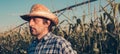 Serious thoughtful farmer in corn field