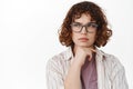 Serious thoughtful girl in glasses, student thinking, looking left at advertisement and pondering, making decision Royalty Free Stock Photo