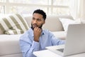 Serious thoughtful young African freelance business man working at laptop Royalty Free Stock Photo