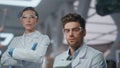 Serious two doctors posing in microbiology laboratory wearing uniform close up. Royalty Free Stock Photo
