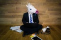 Serious unicorn in a suit and tie enthusiastically works at home with cup of coffee on wooden stand Royalty Free Stock Photo