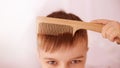 Serious view. Wooden comb. Bright interior. Horizontal