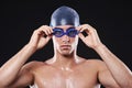 Serious about winning. Studio portrait of a young male swimmer with goggles and cap. Royalty Free Stock Photo